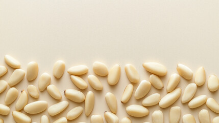 pine nuts: a loose frame made from whole pine nuts, scattered lightly over a light cream background, the pale beige tones of the nuts create a soft, minimalist texture