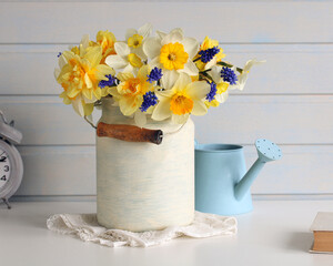 interior of a white cottage, spring bulbous flowers on the table. daffodils and hyacinths. bouquet of garden flowers, season.