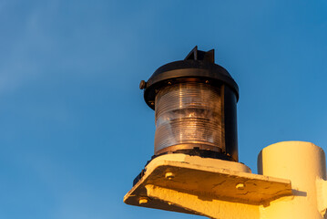 Wall Mural - Close-up of navigation lights on a large cargo ship, the lamps standing out sharply against the clear blue sky. The detail captures the essential maritime equipment.