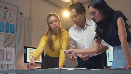Wall Mural - three asian uiux designers are discussing user experience for mobile application development. they a