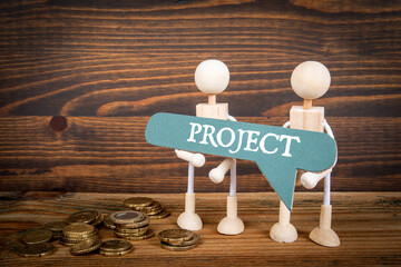 Wall Mural - project concept. green speech bubble with text and two miniature human figures on a wooden backgroun