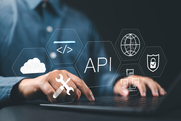 Fototapete - API Application Programming Interface Concept. A programmer types on a laptop, interacting with digital icons representing API development, security, and cloud computing. Application Software Tool,