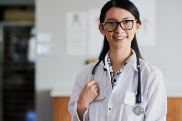 Asian doctor, woman and smile in hospital, portrait and ready with stethoscope for healthcare services. Person, medic and happy for wellness, career or consultation with pride at clinic in Taiwan