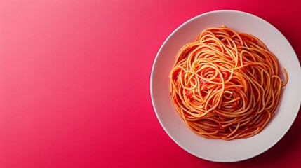 Top view of a plate of spaghetti with tomato sauce on a pink background.