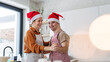 © Halfpoint - Young man with Down syndrome and his mom dancing while baking Christmas gingerbread cookies in kitchen. Christmas peaceful moment for man with Down syndrome.