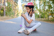 © sementsova321 - Pretty little girl learning to skate on beautiful summer day in park wearing safety helmet and hurt her knee while riding sitting on asphalt road and touching painful leg
