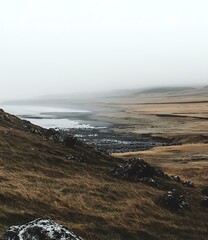 Foggy Coastline with Rolling Hills and a Distant Sea