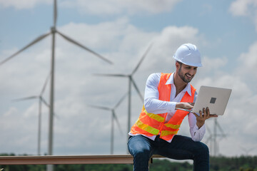 Fototapete - Engineer wearing safety uniform holding laptop discussed plan about renewable energy at station energy power wind. technology protect environment reduce global warming problems.