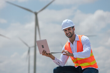 Fototapete - Engineer wearing safety uniform holding laptop discussed plan about renewable energy at station energy power wind. technology protect environment reduce global warming problems.