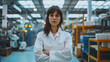 © SS Digital - Female project manager standing in modern industrial factory. Manufacturing facility with robotics, robotic arms and automation. Storing products and materials in warehouse
