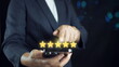 © Bird Photographer TH - close up Woman hand using smart phone and give five star symbol to increase rating of product and service concept, Customer service experience and business satisfaction survey.