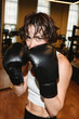 © Westend61 - Woman with boxing gloves posing in gym