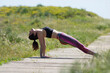 © Westend61 - Woman in plank position doing yoga at footpath in meadow