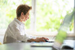 © Westend61 - Businesswoman working on laptop at table