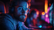 © Mark - Cybersecurity professional wearing glasses, working in front of computer screens filled with code, reflected in his lenses, surrounded by colorful neon lights in a tech workspace