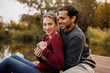 © Dmytro Hai - Happy young couple hugging on pier near lake in autumn