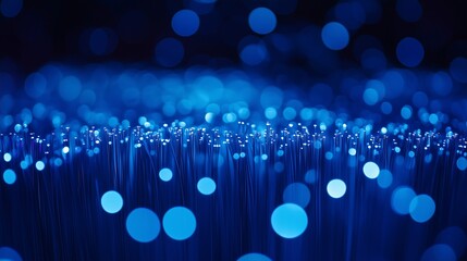Wall Mural - close-up of glowing blue fiber optic strands with bokeh lights, representing advanced digital commun