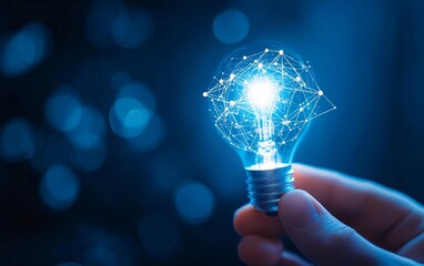 Wall Mural - glowing light bulb held by hand, representing innovation and creativity.