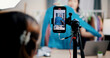 © Johnstocker - Selective focus on mobile phone of Cheerful woman influencer is live streaming sell clothes on social media or blogging in home studio. Remote buying, Online shopping, Sell ​​products online