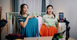 © Johnstocker - Portrait of Two cheerful woman influencers are live streaming sell clothes on social media or blogging in home studio. Remote buying, Online shopping, Sell ​​products online