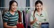 © Johnstocker - Portrait of Two cheerful woman influencers are live streaming sell clothes on social media or blogging in home studio. Remote buying, Online shopping, Sell ​​products online