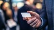 © Pornnapa - A close-up of a business professional handing over a business card, with a blurred background of a networking scene