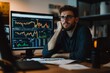 © fotofabrika - Focused man analyzing financial data on a computer screen in a dimly lit office during the evening