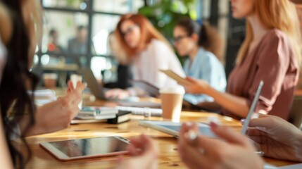 Sticker - Professionals engage in a lively discussion in a well-lit modern office, with tablets and coffee cups on the table, exuding creativity and productivity.