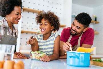 Wall Mural - happy african american family preparing healthy food in kitchen, having fun together on weekend