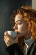 © serperm73 - Young woman drinking coffee. Solid color backdrop.