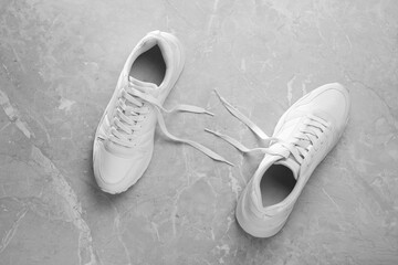 Pair of stylish sneakers on grey marble background, top view