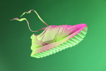 Wall Mural - Stylish sneaker in air against green background in neon lights