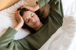 © Wavebreak Media - Lying in bed, woman holding head and experiencing headache or stress