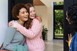 © Wavebreak Media - Hugging and smiling, two women friends greeting each other at home entrance