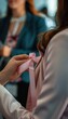 © spyrakot - Breast Cancer Awareness Ribbon - Close-Up of Woman Holding Pink Ribbon in Office Setting