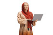 © Ljupco Smokovski - Young woman wearing a hijab and holding a laptop computer