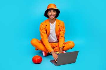 Wall Mural - Photo of positive guy sit use netbook search browsing halloween events online wear stylish outfit isolated cyan color background