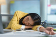 © amnaj - Businesswoman is sleeping at her desk with her head on her arms, exhausted after working late on a project