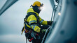 © kongkiat chairat - Worker climbing a wind turbine, isolated view