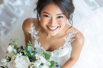 Beautiful bride wearing a white wedding dress, holding a colorful bouquet of flowers in her hand and smiling at the camera