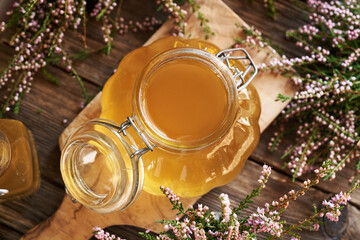 Canvas Print - Herbal syrup in a glass jar with wild heather flowers on a wooden table