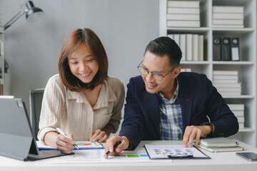 Poster - Businessman and businesswoman are discussing and analyzing financial charts at their desks in the office