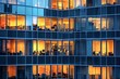© Oleh - Warm lights are illuminating the offices of a contemporary glass building where employees are working late into the night