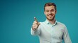 © Ace64 Studio - Portrait of cheerful businessman pointing at copy space for advertising against blue background.