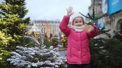 Wall Mural - Happy cheerful preschooler girl on a Christmas market in Paris, France.