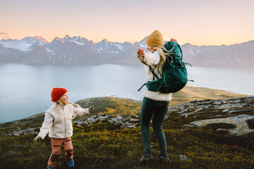 Wall Mural - mother and daughter child hiking together in norway, family having fun in mountains travel outdoor a
