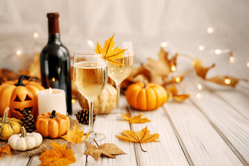 Wall Mural - Halloween & Thanksgiving wine party background, decorated with a wine glass, a wine bottle, a Jack-o-lantern, pumpkins, and fallen leaves on a white wall, a festive and elegant feel with bokeh effects