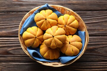 Sticker - Wicker basket with tasty pumpkin shaped buns on wooden table, top view