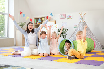 Canvas Print - Little children with nursery teacher playing in kindergarten