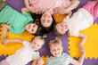 © Pixel-Shot - Little children with nursery teacher holding hands on floor in kindergarten, top view